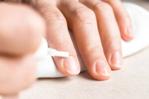 Female hand applying nourishing oil on cuticles